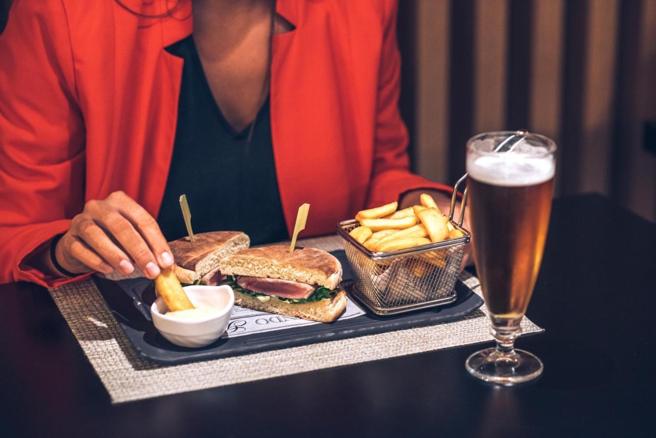 Iberostar Selection Lisboa Hotel Exterior foto A woman eating a hamburger and chips